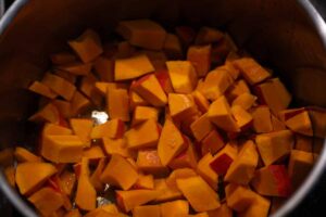 Hokkaido-Kürbis wird in Spalten geschnitten und für die Zubereitung der Kürbissuppe vorbereitet