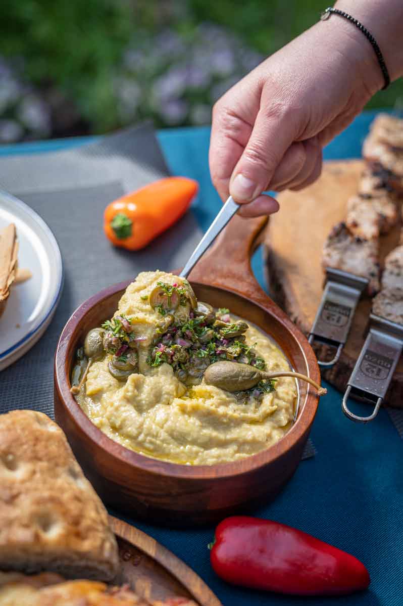 Cremiger Fava Dipp aus griechischen Platterbsen, serviert mit Kapern-Topping und Petersilie in einer Schale