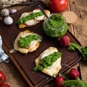 Rezept für mediterran überbackene Hähnchenschnitzel mit Radieschengrün Pesto