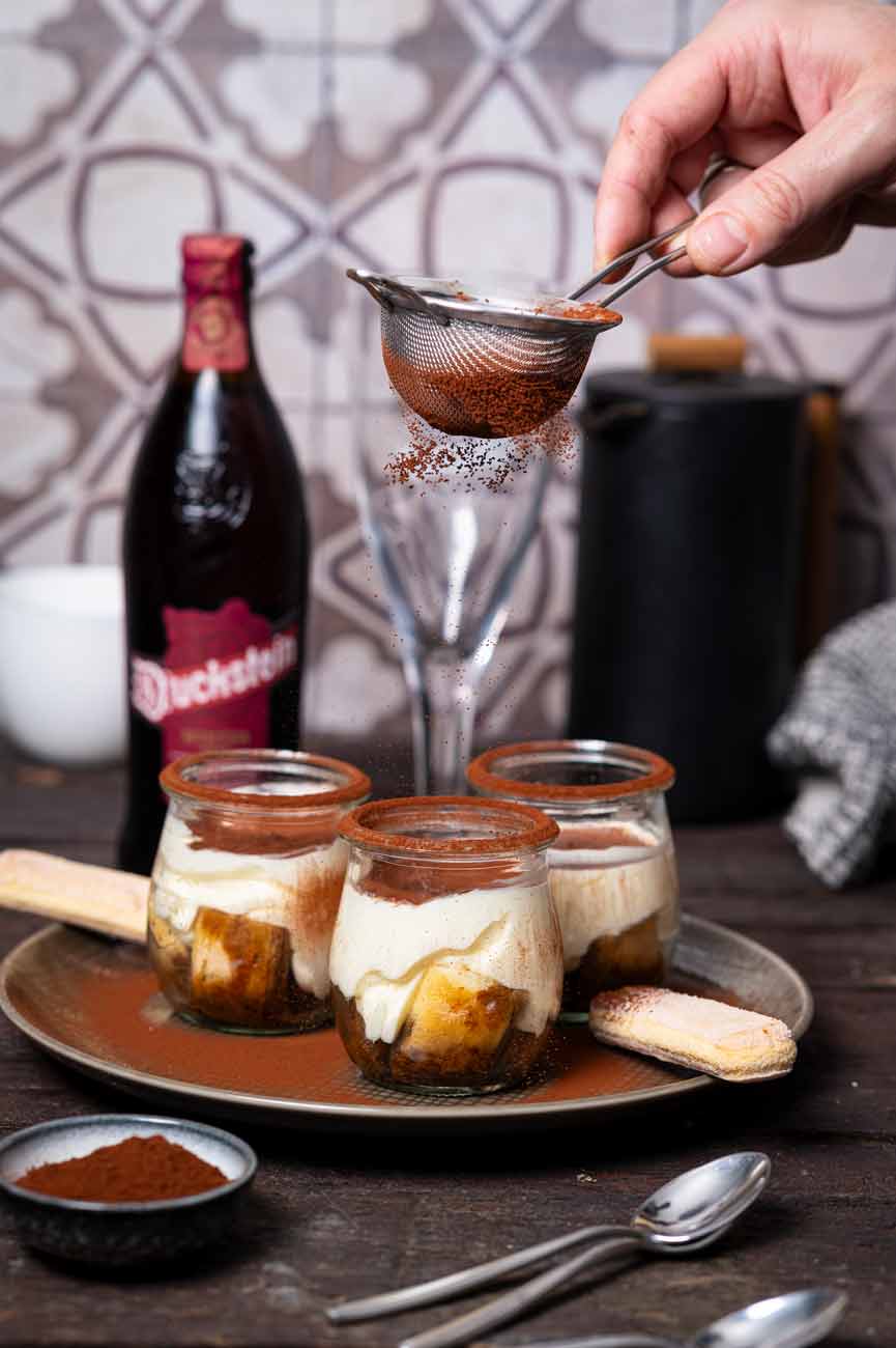 Tiramisu ohne Ei im Glas, geschichtet mit Löffelbiskuits, Mascarponecreme und Kakaopulver, serviert als einfaches Dessert ohne rohes Ei