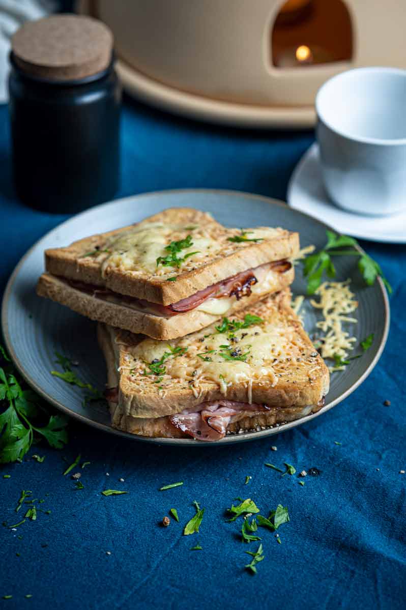 Frisch gebratenes Croque Monsieur Sandwich mit geschmolzenem Käse, goldbraunem Toast und Schinken auf einem Teller serviert