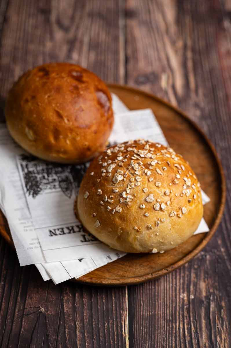 Frisch gebackene Potato Rolls aus Kartoffelteig – fluffige, goldbraune Burger Buns auf einem Holzbrett, ideal für selbstgemachte Burger