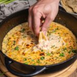 Chili con Queso Dip mit geschmolzenem Käse, Paprika, Zwiebeln und Frühlingszwiebeln, serviert mit Tortillachips – cremiger Käse-Dip, perfekt für Partys.