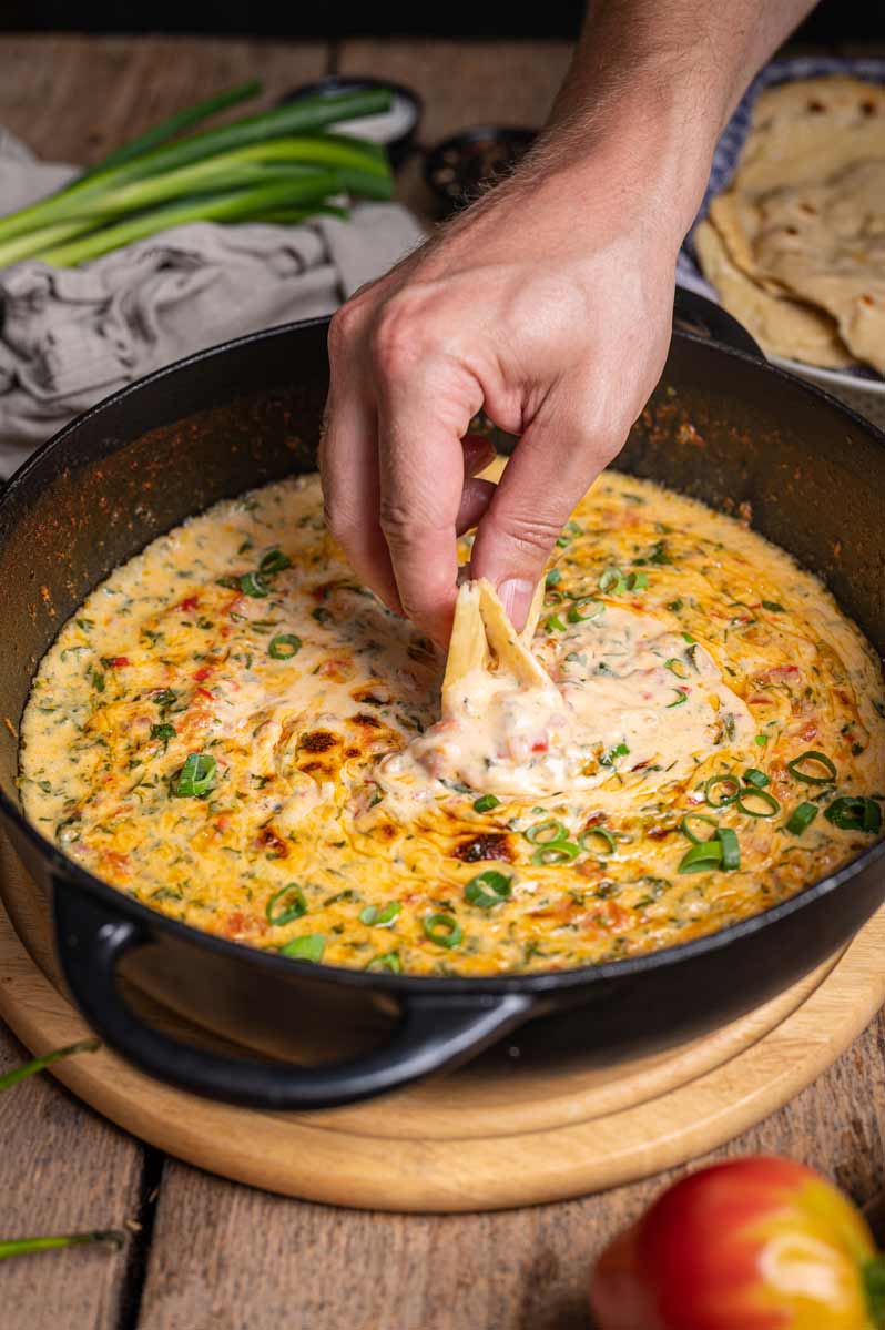 Chili con Queso Dip mit geschmolzenem Käse, Paprika, Zwiebeln und Frühlingszwiebeln, serviert mit Tortillachips – cremiger Käse-Dip, perfekt für Partys.