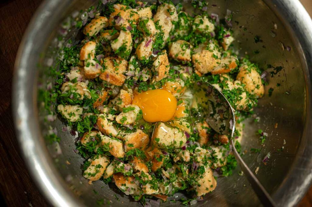 In Stücke geschnittene alte Brötchen in einer Schüssel – Grundlage für das klassische Serviettenknödel Rezept.