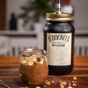 Cremige Mousse au Chocolat mit Harte Nuss Cream von O’Donnell, serviert in einem Glas und mit gerösteten Nüssen bestreut.