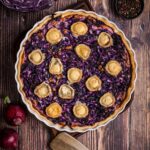 Frisch gebackene Rotkohl Quiche mit Ziegenkäse und Walnüssen auf einem Holzbrett