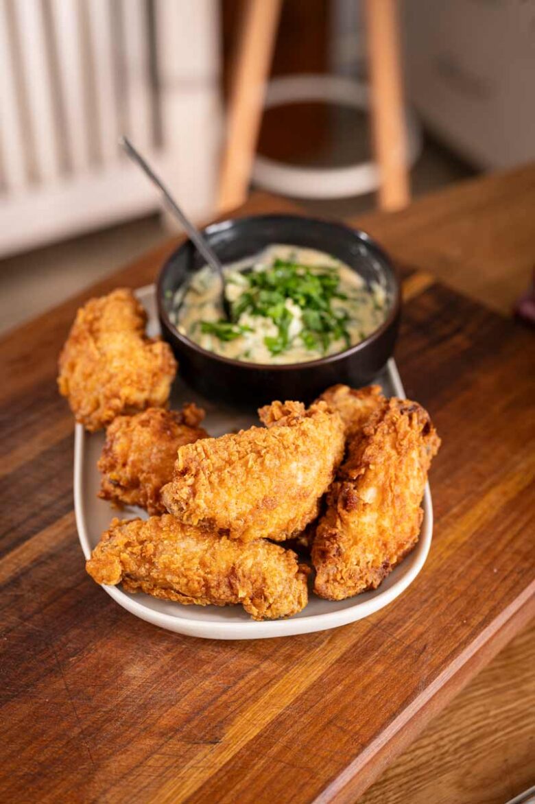 Knusprige Buttermilk Fried Chicken Wings auf einem Teller, serviert mit frischer Bärlauch-Mayonnaise als Dip