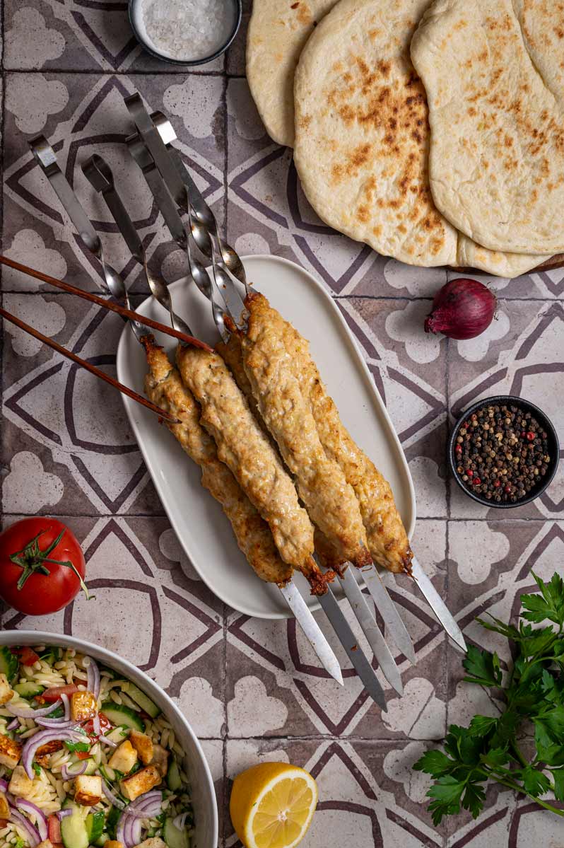 Goldbraun gebackene Hähnchen Kebab Spieße auf einem Backblech, direkt nach dem Garen im Ofen