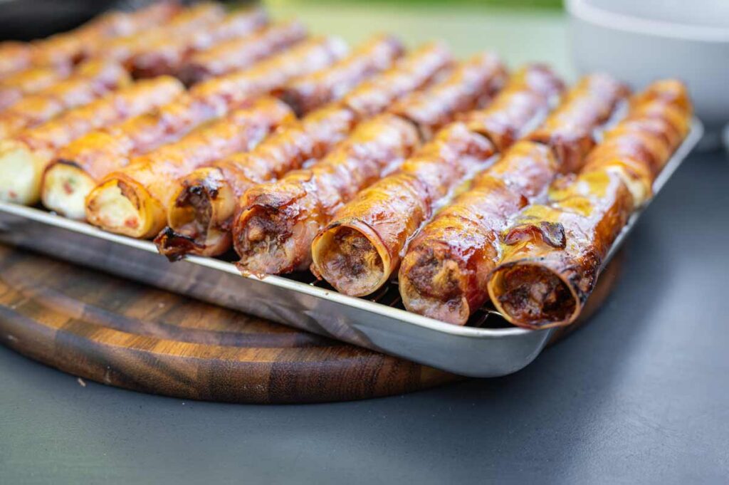 Nahaufnahme von gefüllten Cannelloni im Baconmantel mit BBQ-Glasur – perfekt gegart vom Kugelgrill