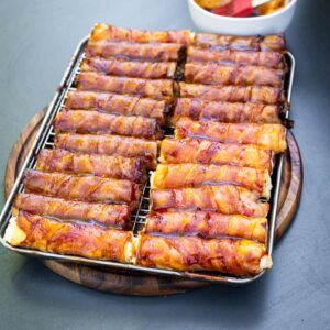 Fertig gegrillte Shotgun Shells mit glänzender BBQ-Glasur, angerichtet auf dem Holzbrett mit Messer