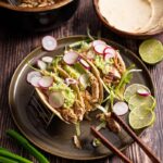 Guacamole, Eisbergsalat, Maistortillas und Pulled Chicken als Taco Füllung vorbereitet