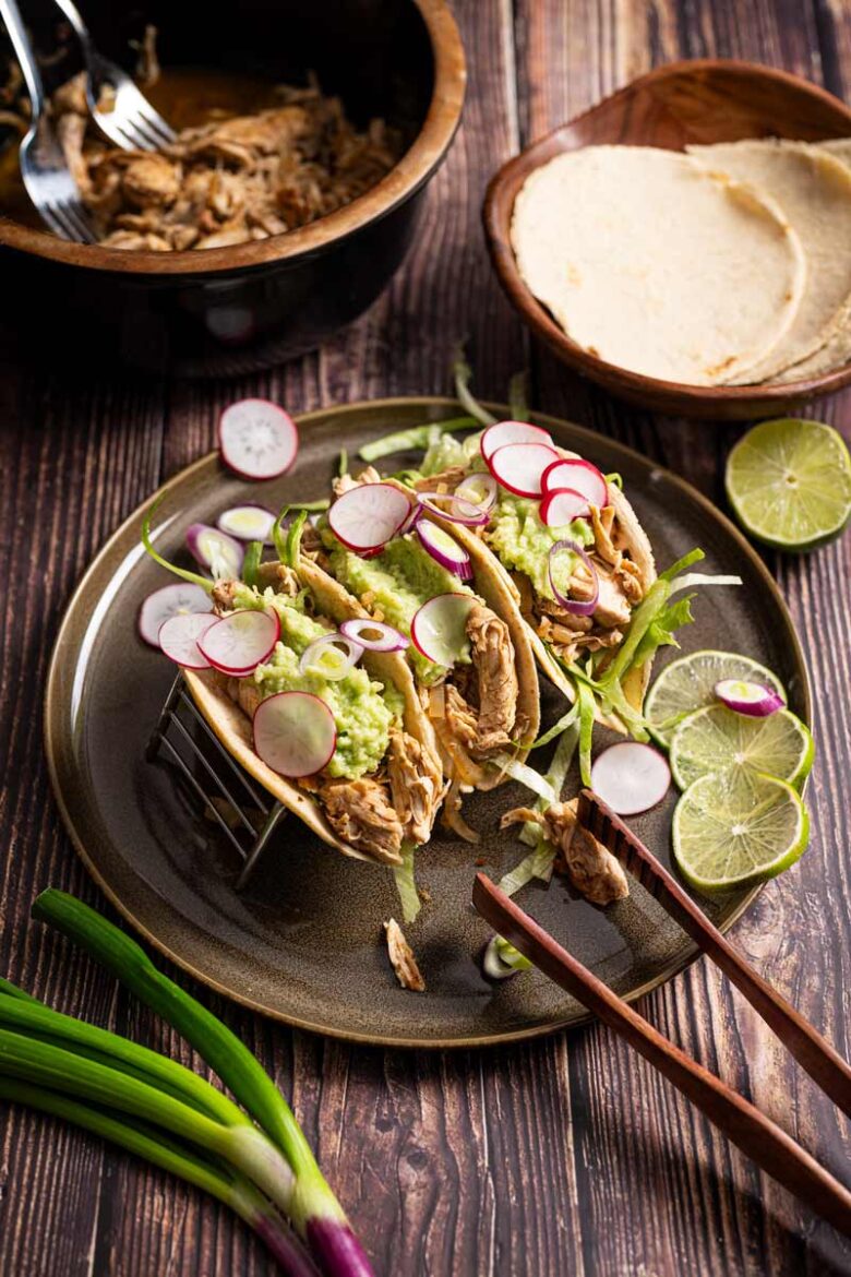 Guacamole, Eisbergsalat, Maistortillas und Pulled Chicken als Taco Füllung vorbereitet