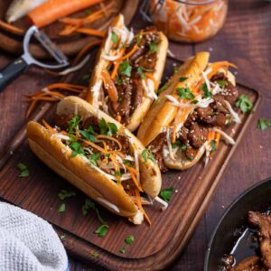 Fertiges Banh Mi Sandwich mit Fleisch Möhren und Gurke serviert auf Holzbrett