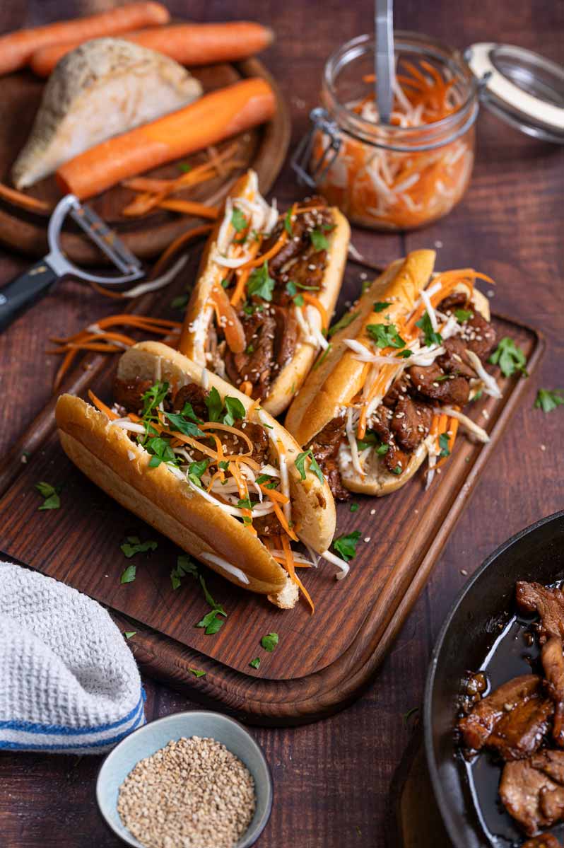 Fertiges Banh Mi Sandwich mit Fleisch Möhren und Gurke serviert auf Holzbrett