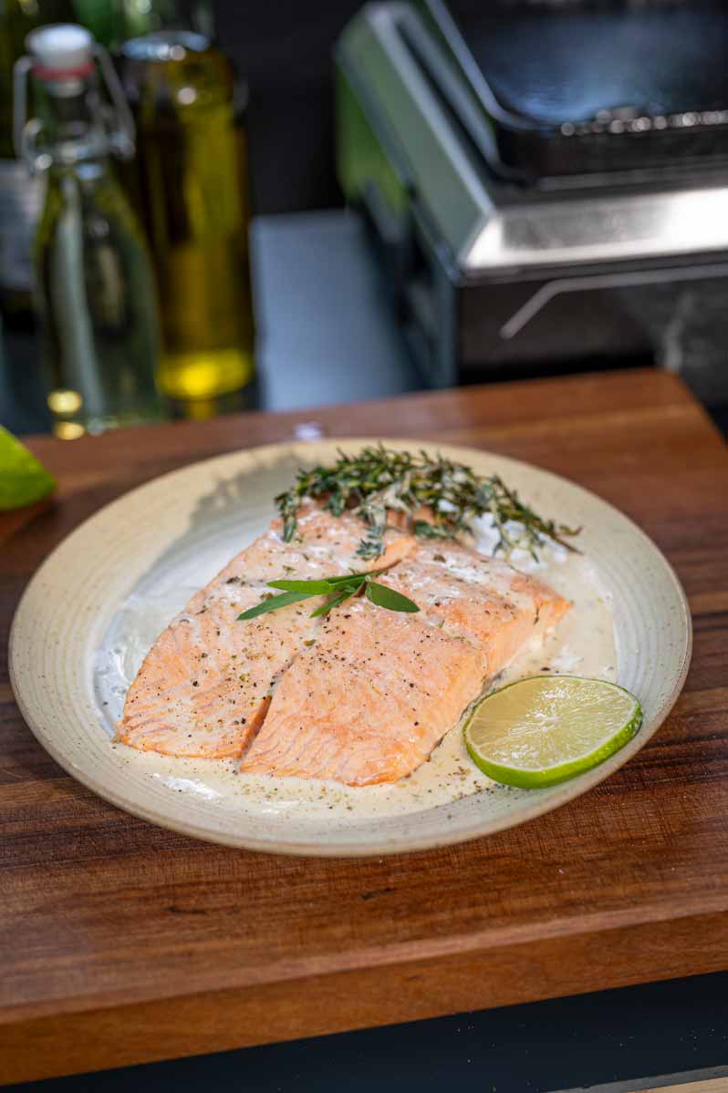 Gegrillter Lachs mit knuspriger Haut auf der Plancha, frisch gewürzt mit Salz und Pfeffer
