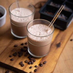 Selbstgemachter Eiskaffee ohne Eis, fotografiert von oben – dunkle, cremige Textur im Glas