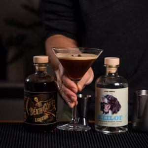 Fertiger Espresso Martini mit cremiger Schaumkrone und drei Kaffeebohnen als Garnitur im Martiniglas.