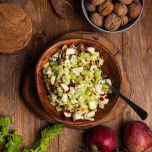 Frischer Apfel Sellerie Salat mit Äpfeln, Staudensellerie und gehackten Walnüssen in einer Schüssel angerichtet