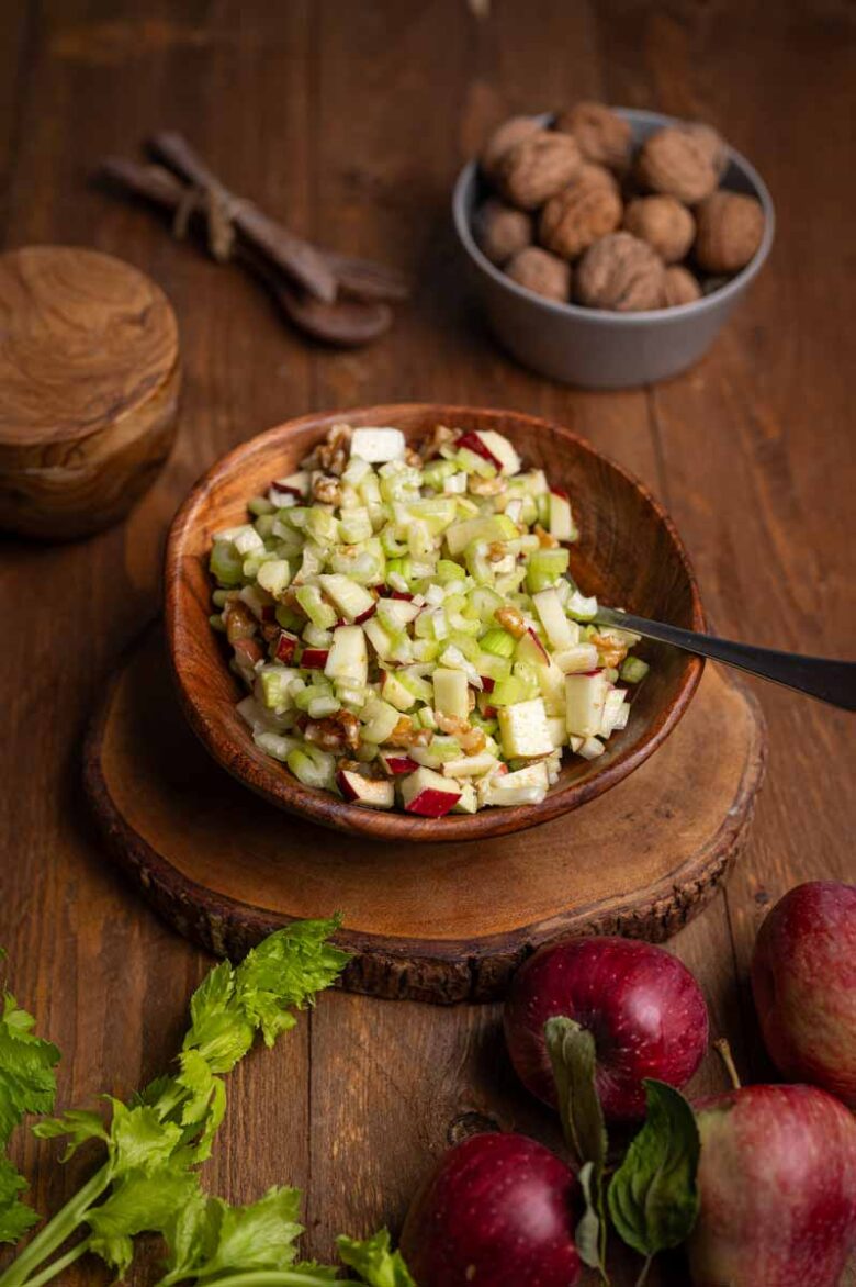 Nahaufnahme einer Gabel mit Apfel Sellerie Salat, knackigen Selleriescheiben, Apfelstücken und Walnüssen