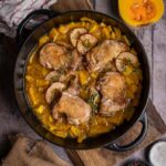 Saftiges Apfel-Cider-Hähnchen mit gebratenem Butternut-Kürbis und Apfelscheiben auf einem Teller serviert.