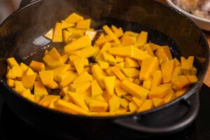 Vorbereitung der Zutaten für das Apfel-Cider-Hähnchen mit Butternut-Kürbis in der Küche.