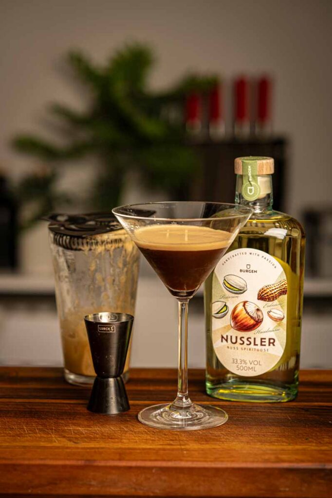 Cremiger Nussiger Espresso Martini mit Burgen Nussler auf einem dunklen Holztisch