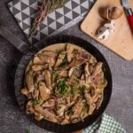 Cremiges Geschnetzeltes mit Pilzen in der Pfanne, serviert mit Reis.