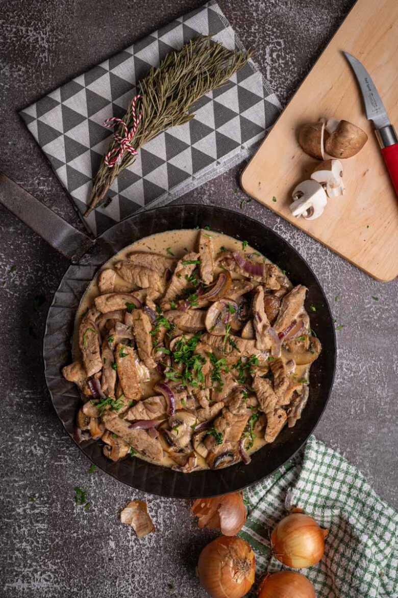 Cremiges Geschnetzeltes mit Pilzen in der Pfanne, serviert mit Reis.