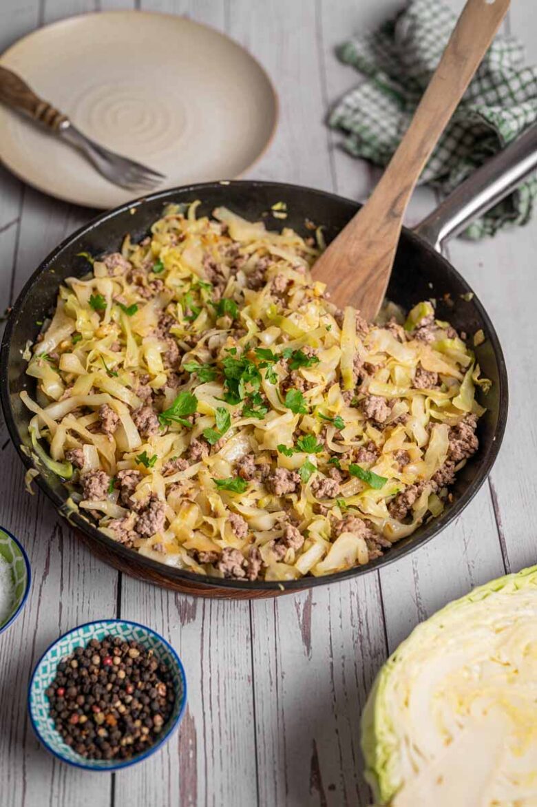 Hackfleisch und Spitzkohl gemeinsam in der Pfanne während der Zubereitung