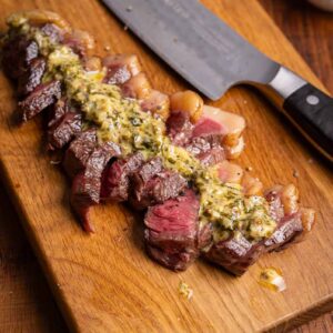 Saftiges Steak mit geschmolzener Café de Paris Sauce und frischen Kräutern.