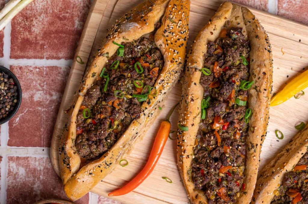 Servierte Pide mit Hackfleisch, Petersilie und schwarzem Kümmel