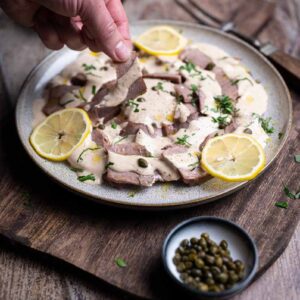 Fertig zubereitete Schweinezunge Tonnato mit cremiger Thunfisch Soße und frischer Petersilie