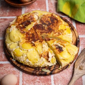Saftige spanische Tortilla mit Kartoffeln angeschnitten auf Teller