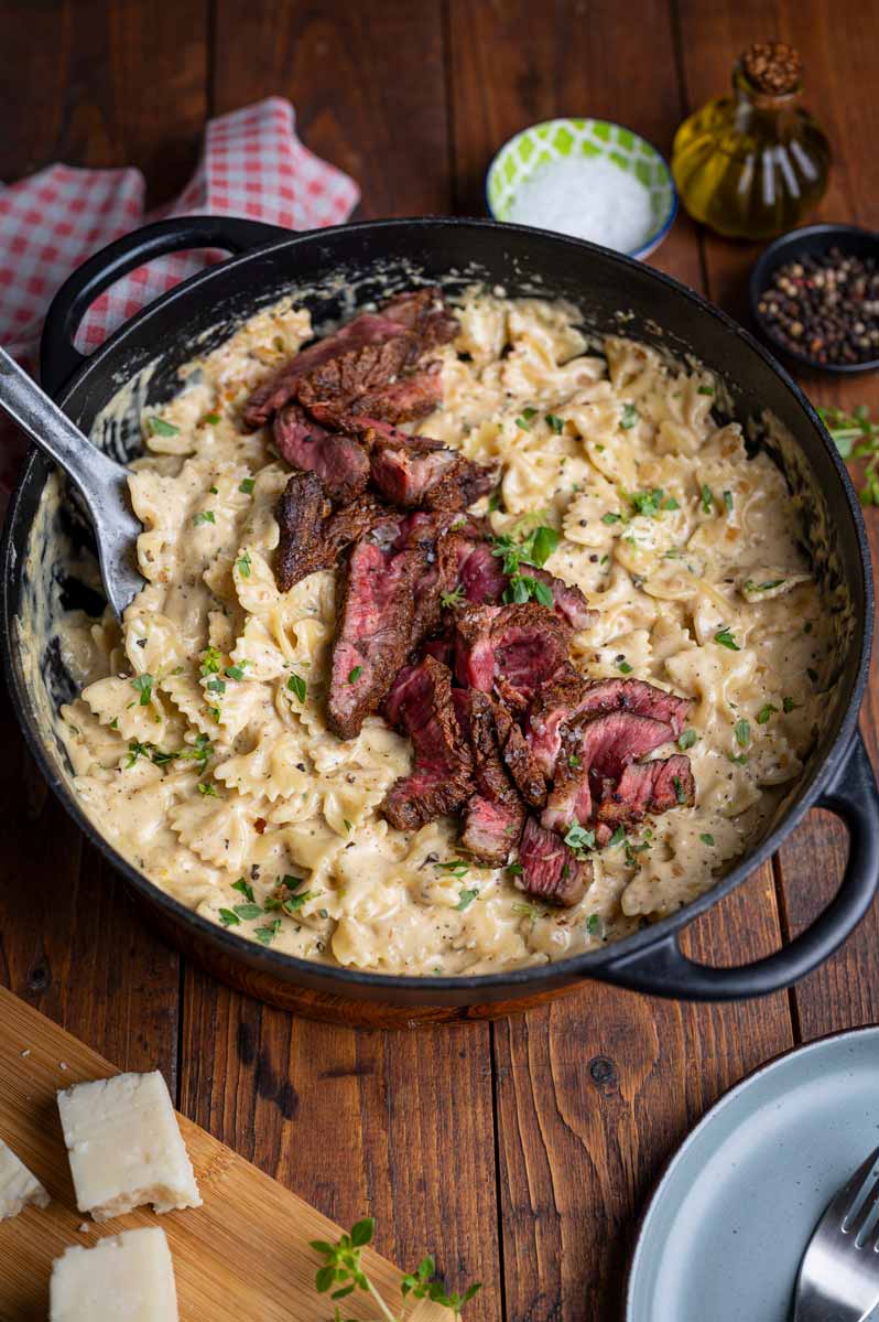 Cremige Pasta Alfredo mit zart gebratenem Entrecôte, Farfalle und frisch geriebenem Parmesan.