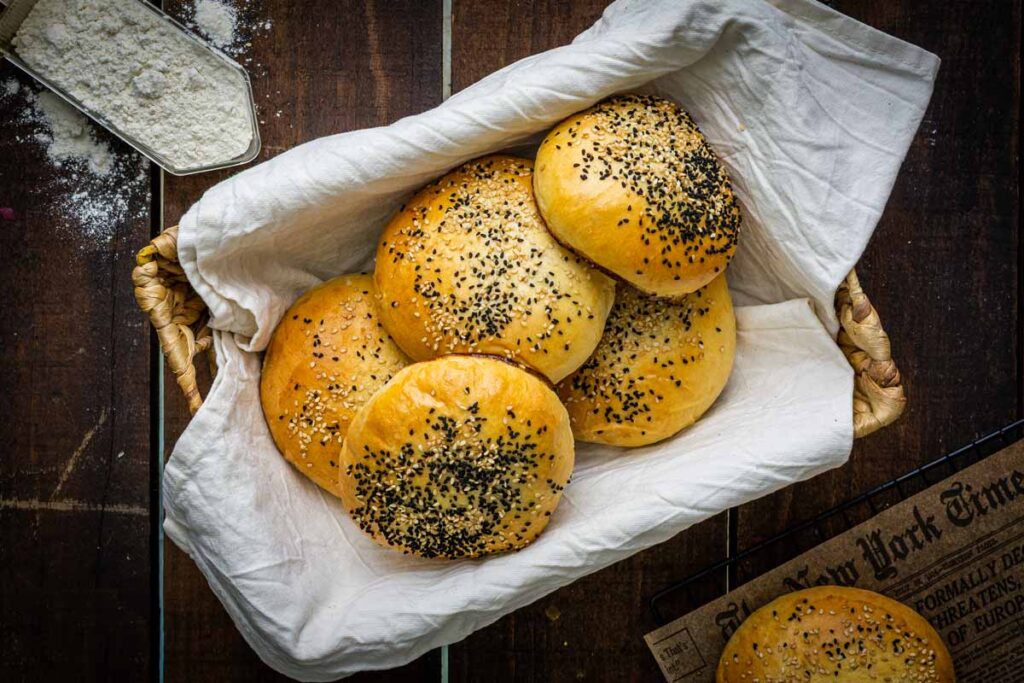 Fluffige selbst gemachte Burger Buns mit Sesam auf einem Brett