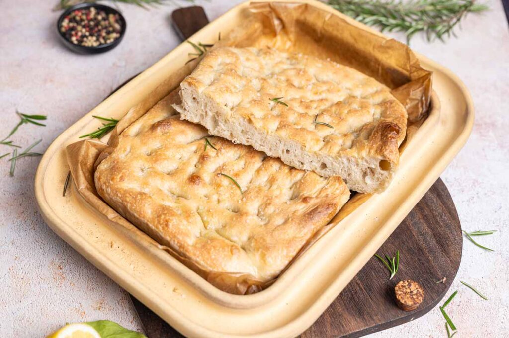 Frisch gebackene Sauerteig-Focaccia mit Rosmarin, Olivenöl und goldbrauner Kruste