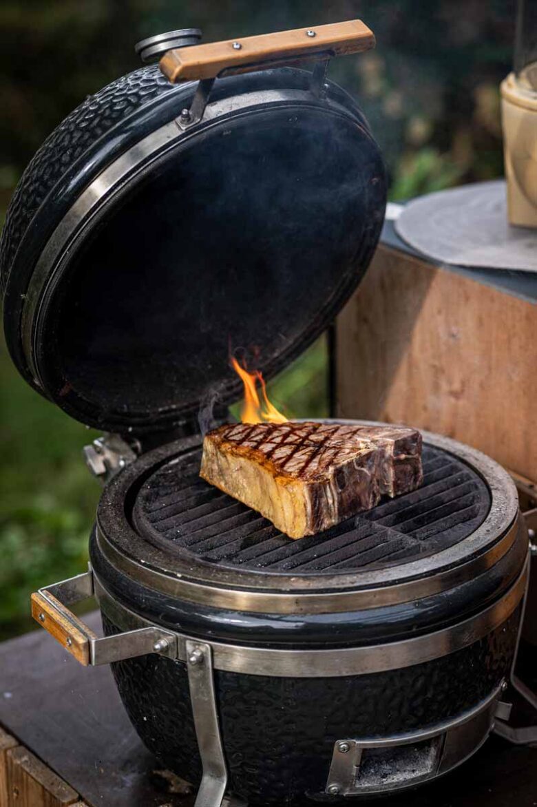 Dickes Rindersteak brät bei hoher direkter Hitze auf dem Grillrost